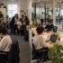 Employees working collaboratively in a busy office, highlighting signs that a company has outgrown its current office space.